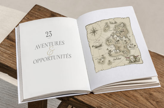 Un livre qui s'ouvre sur le chapitre 23 pour fêter les voeux de la nouvelle année avec une carte aux trésors et un titre Aventures et Opportunités