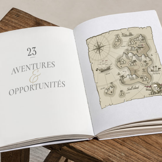 Un livre qui s'ouvre sur le chapitre 23 pour fêter les voeux de la nouvelle année avec une carte aux trésors et un titre Aventures et Opportunités