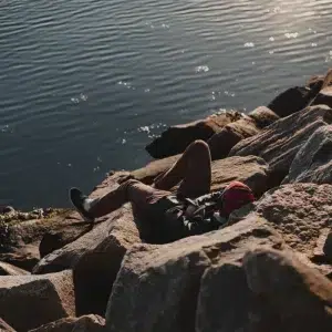 Une personne se repose au bord de l'eau.