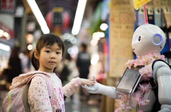 Une petite fille touche la main d'un robot japonais