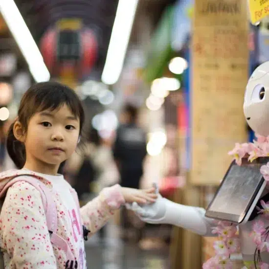 Une petite fille touche la main d'un robot japonais