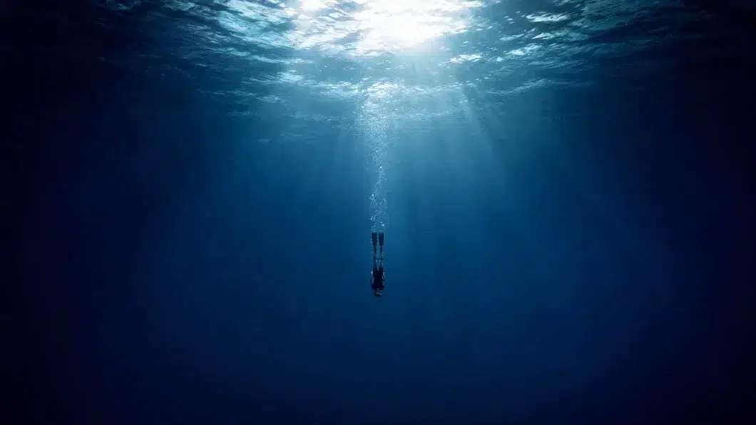 Un plongeur descend dans la mer. L'IA permet de plonger en soi.
